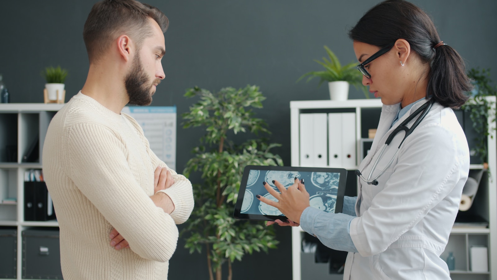 Doctor showing a CT scan to a patient on a tablet